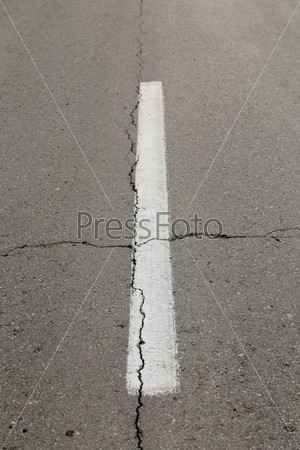 Piece of road with white band. Cracked. Close up.