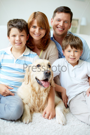 Portrait of happy family with their pet looking at camera