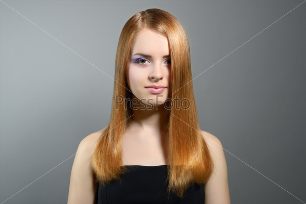 Attractive girl with straight hair on gray background