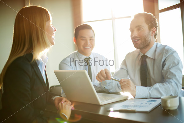 Portrait Of Smart Business Partners Communicating At Meeting