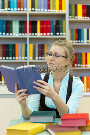 Portrait of clever student with open book reading