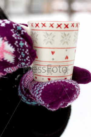 Cozy red gloves hold a mug