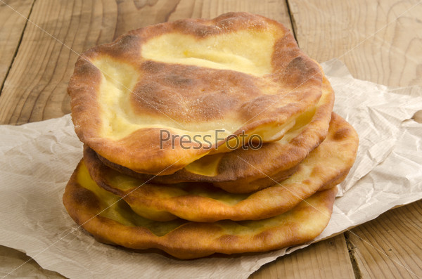 Langos, home made Hungarian pancake on brown kitchen paper, stock photo