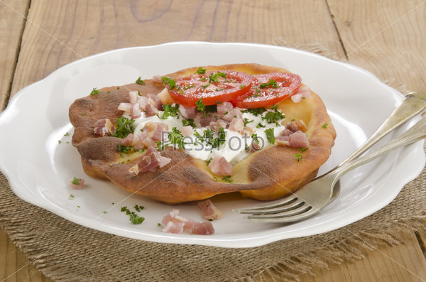 Langos, home made Hungarian pancake with tomato and bacon