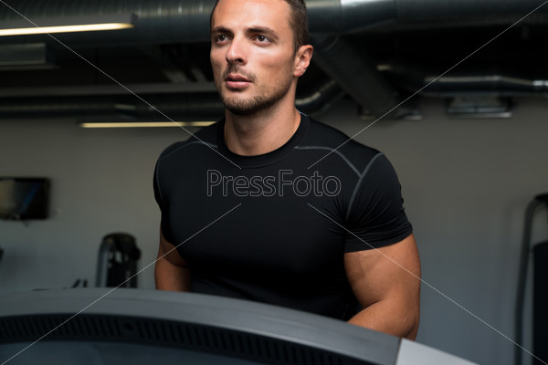 Running On Treadmill In Gym. Man Running On Treadmill At A Health Club