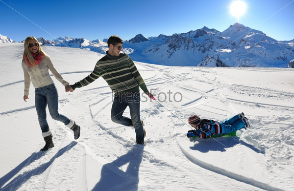 Семья играет в снегу на зимних каникулах