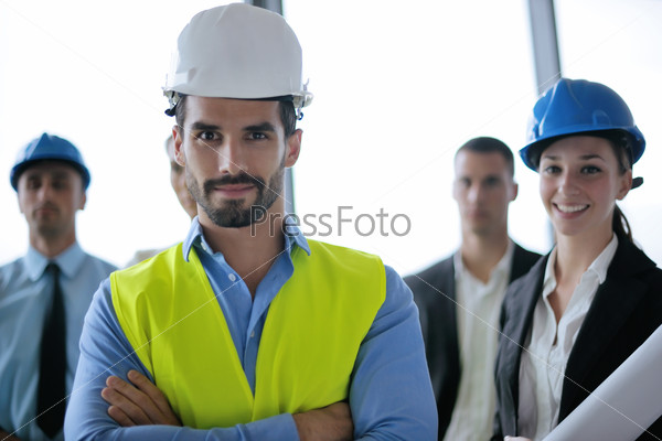Business people group on meeting and presentation in bright modern office with construction engineer architect and worker looking building model and blueprint plans, stock photo