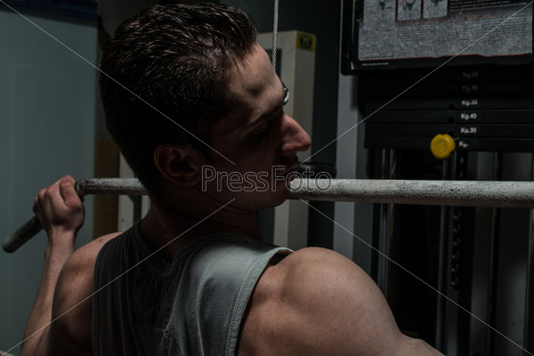 young body builder doing heavy weight exercise for back