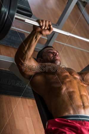 shirtless body builder doing bench press for chest