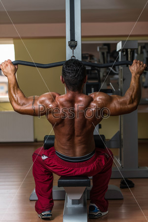 Shirtless bodybuilder doing heavy weight exercise for back, stock photo