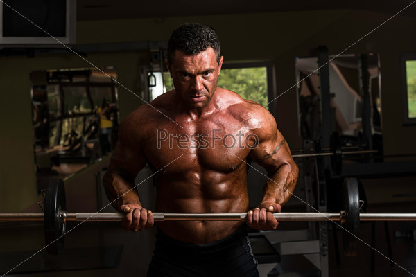 body builder doing heavy weight exercise for biceps with dumbbell