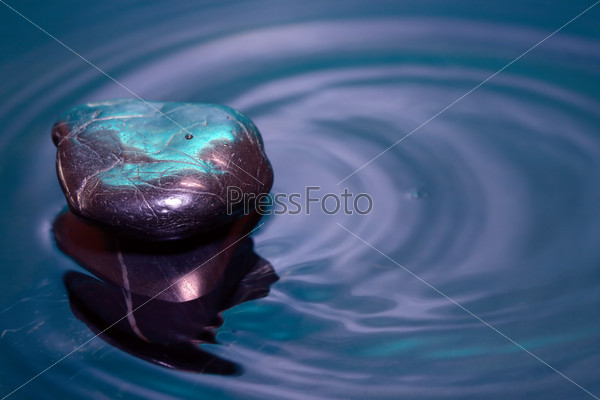 Meditation concept. Stack of stones on dark calm water