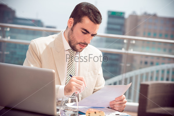 Copy-spaced image of a young businessman busy with strategy analysis while lunch