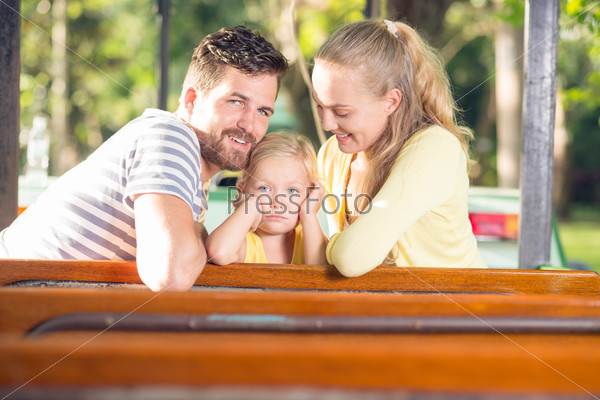 Image of a young family resting in the park where a little girl is sad on the foreground