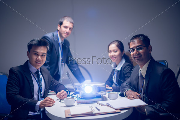 Portrait of a business team at the company\'??s presentation with a projector on the foreground