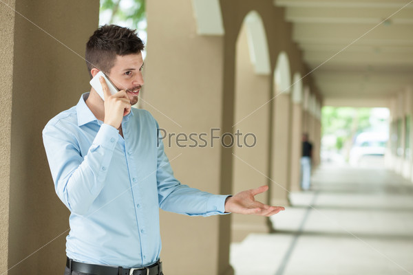 Copy-spaced image of a businessman having emotional telephone conversation on the foreground
