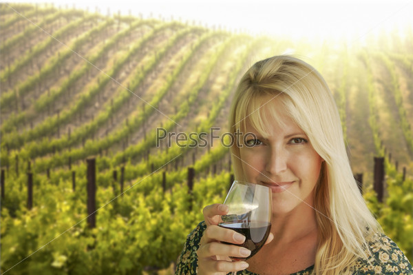 Happy Attractive Woman Enjoying a Glass of Wine at the Vineyard.