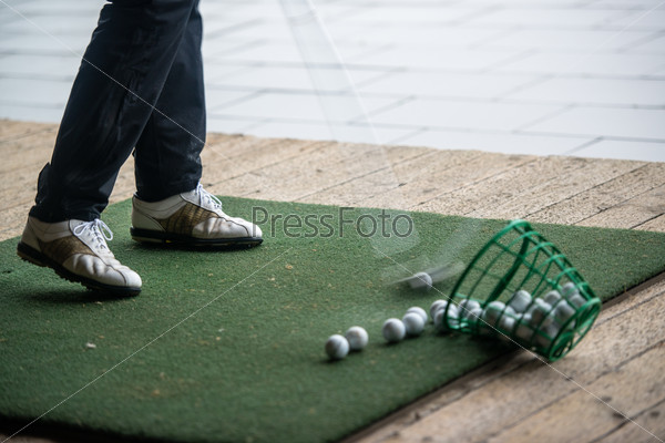 Man hits range balls at the practice area of a golf course, stock photo