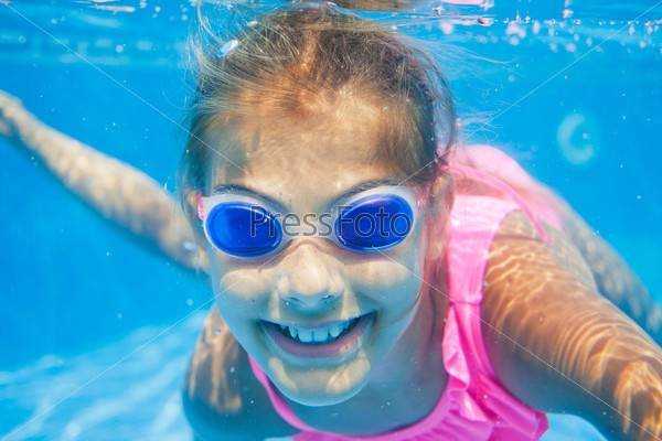 Close-up portrait of the cute girl swimming underwater and smiling