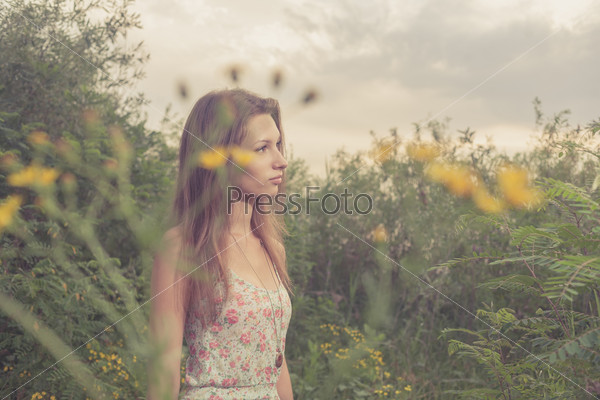 Beautiful Young Woman in Meadow of Flowers.