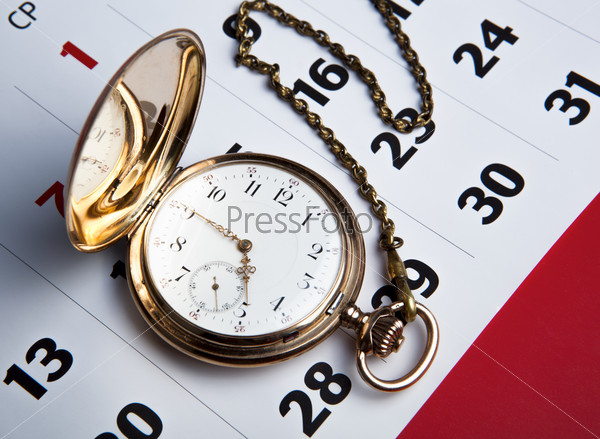 Gold pocket watch and a wall calendar