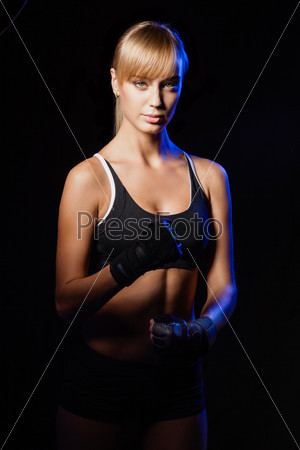 Athletic beautiful blonde woman posing over dark background, stock photo