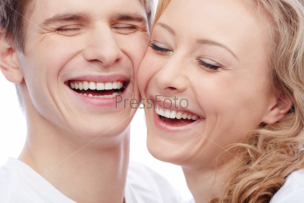 Faces of amorous young couple laughing with closed eyes
