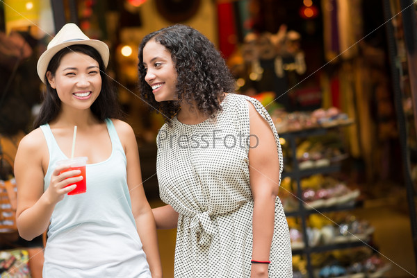 Two female friends talking and laughing in store