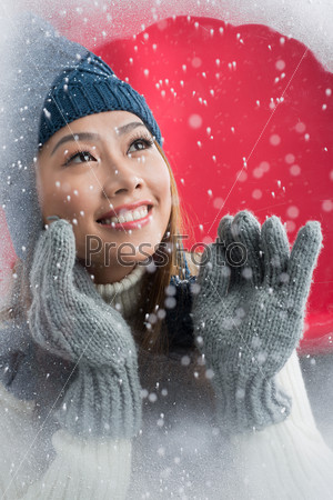 Portrait of a happy woman at snowy window