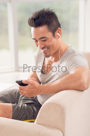 Vertical shot of a happy guy listening to his favorite music