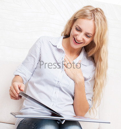 Woman looking photo book. Female looking photography album