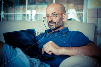 Miggle age man using notebook at home, stock photo