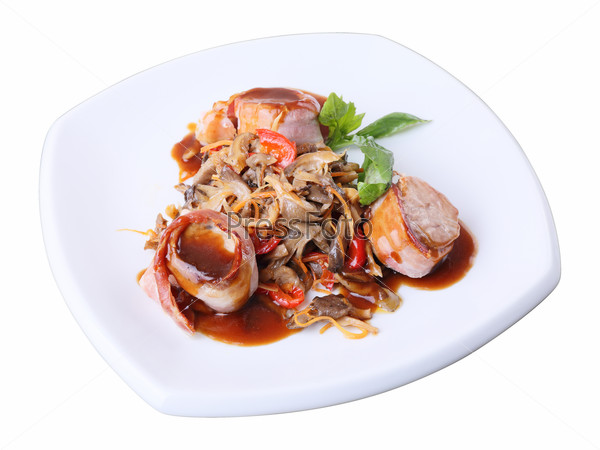 Three medallions of pork wrapped in bacon with oyster mushrooms and sauce  on a white dish isolated over white background. Side view.