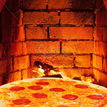 italian pizza with salami and hot brick wall of wood burning oven