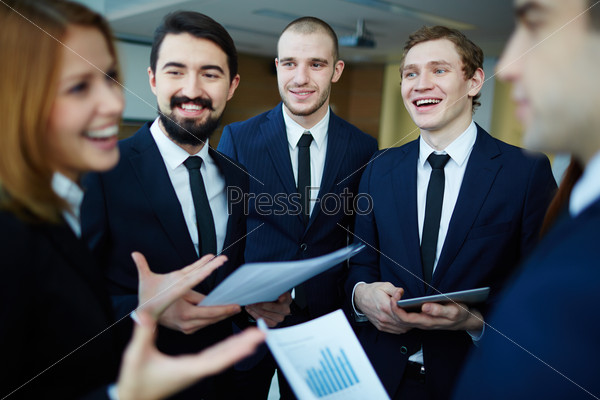 Group of business partners listening to their female co-worker explaining ideas at meeting