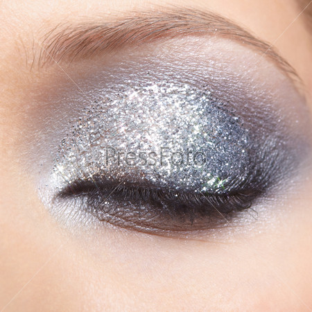 Closed eye of young woman with vogue shining sparkle makeup