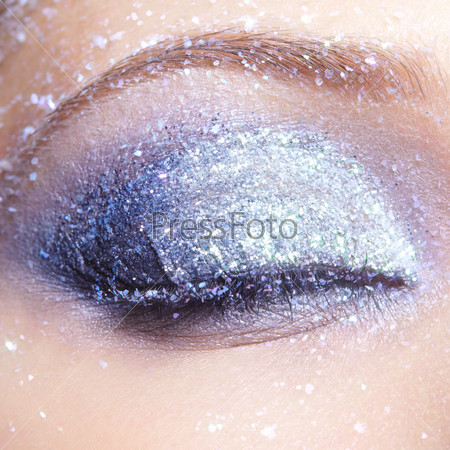 Closed eye of young woman with vogue shining sparkle makeup