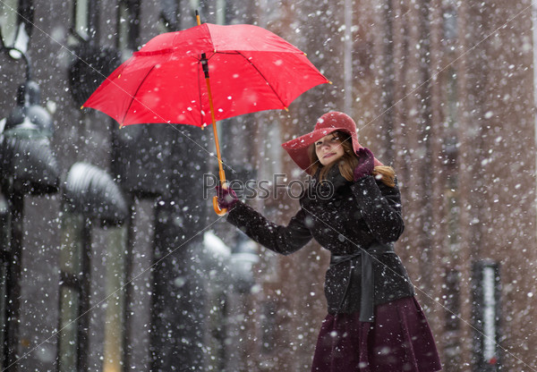 Happy woman at winter day with red umbrella