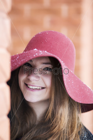 Zoomed smiling woman at day near brick wall