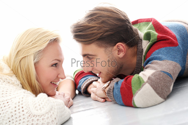 Cute man and beautiful girl smiling on the ground, stock photo