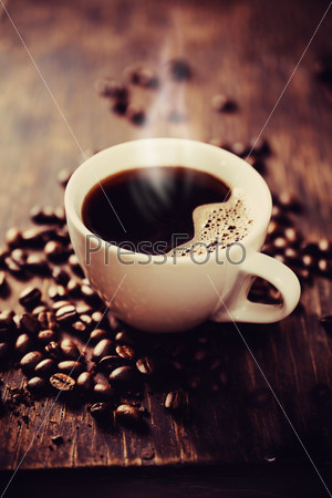 Чашка свежесваренного кофе. На деревянном столе