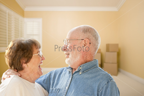 Happy Senior Couple In Room with Moving Boxes on the Floor.