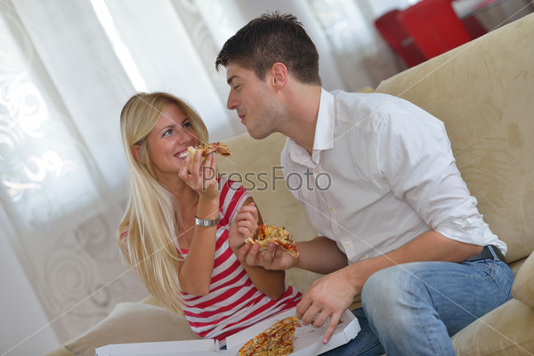 couple at home eating pizza