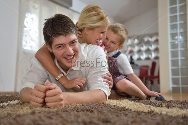 happy young family with kids in bright modern living room have fun and looking big flat lcd tv