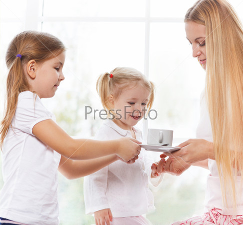Happy mother and daughters playing in the bedroom in the Mother\'s Day