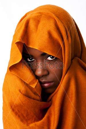 Beautiful mysterious african nomadic bedouin female face in ocher Earth tone head wrap scarf looking.