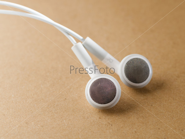 white Headphones, concept of digital music, on a light brown paper