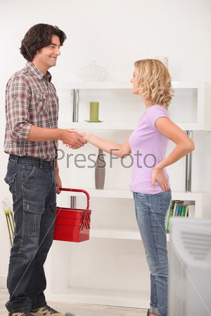 A maintenance man shaking hand with the homeowner.
