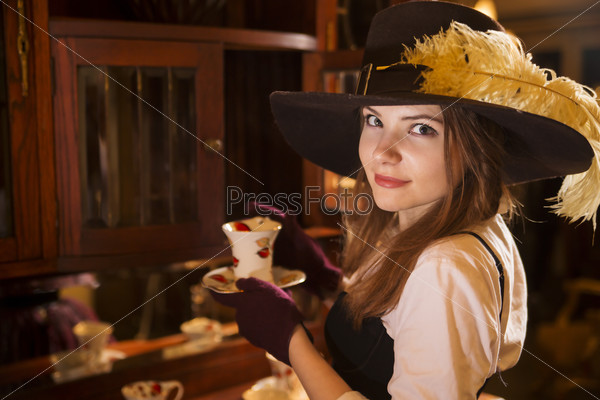 Zoomed woman at fashioned dress with porcelain cup