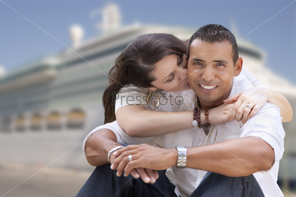 Young Happy Hispanic Couple Hugging On The Dock In Front of a Cruise Ship.
